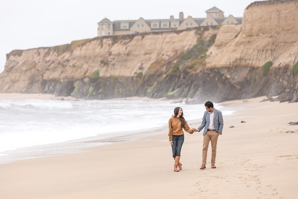 engaged couple walking on the beach at Ritz Carlton