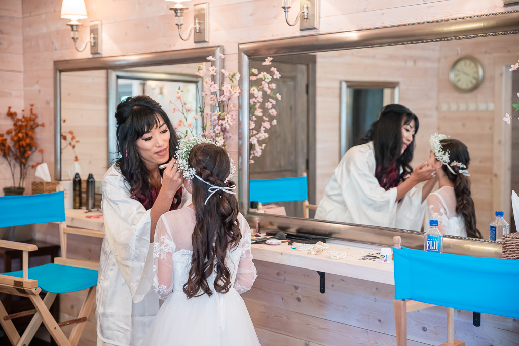 bride putting on touch ups for her daughter before wedding