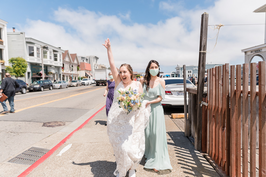 excited bride waving to people on the street