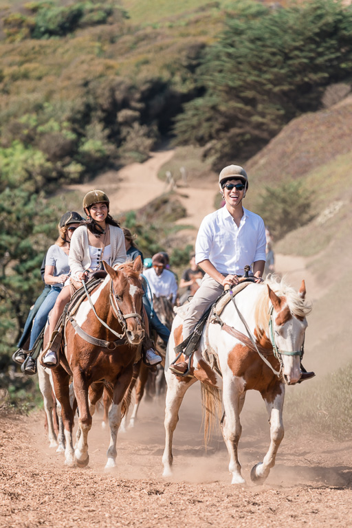 couple riding on horseback on Bay Area trail near Fort Funston