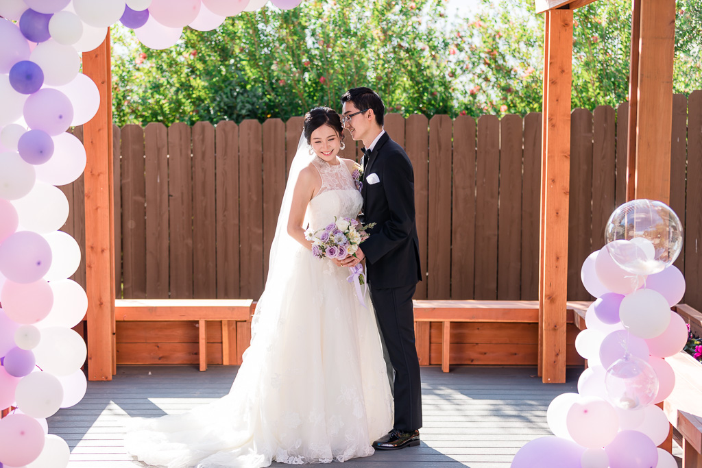 portrait of bride and groom with purple balloons