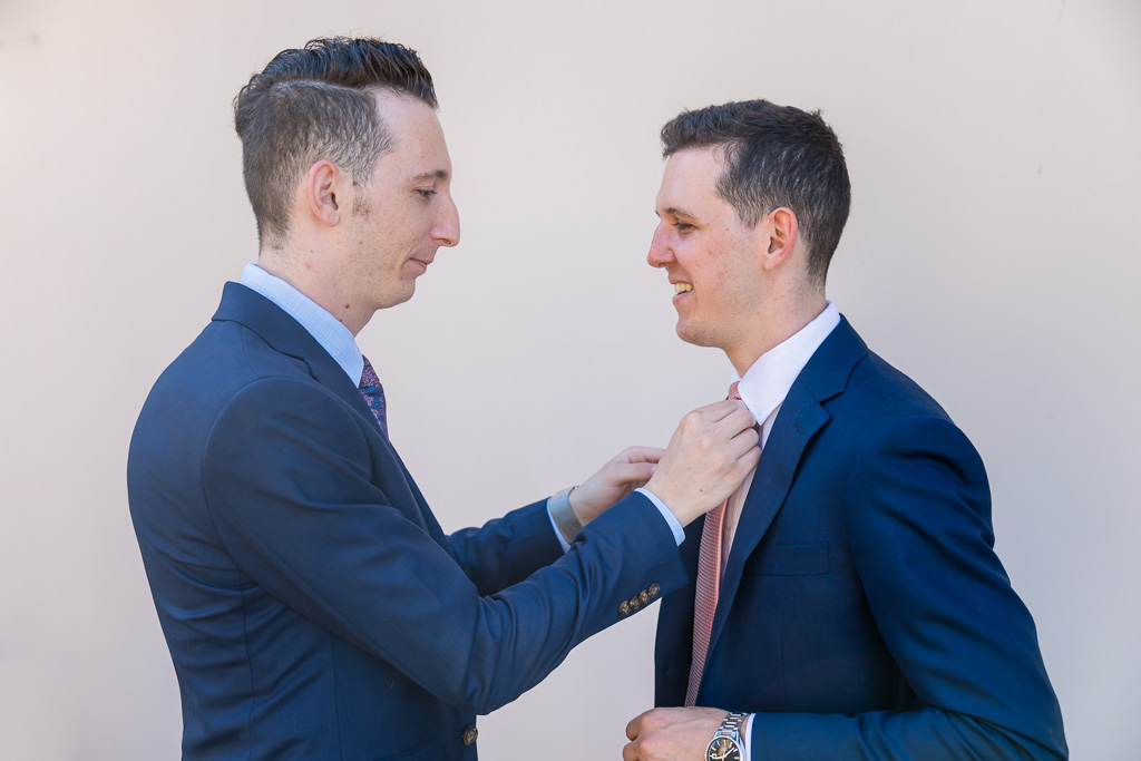 groom's brother helping him with his tie