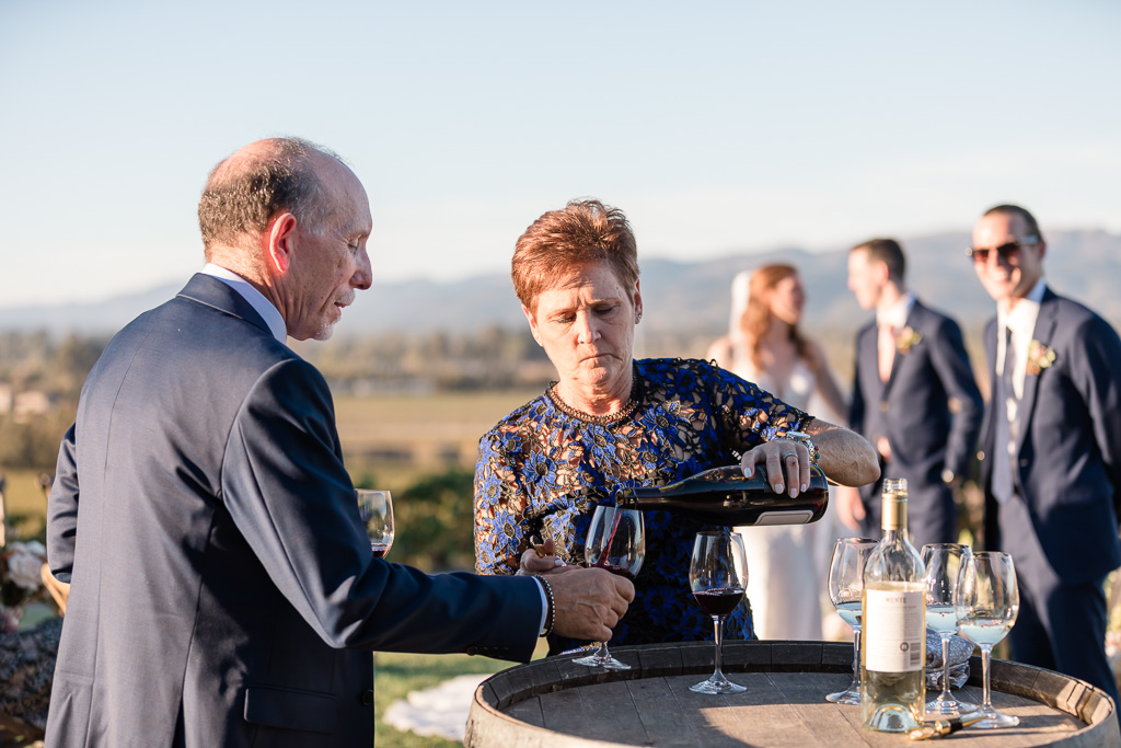 parents of the groom pouring wine during wedding ceremony