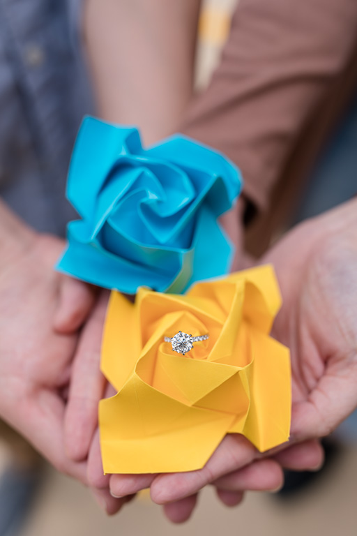 engagement ring inside yellow and blue folded paper flowers