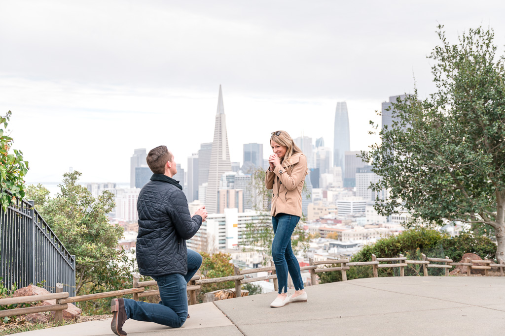 surprise proposal showing San Francisco skyline in the background