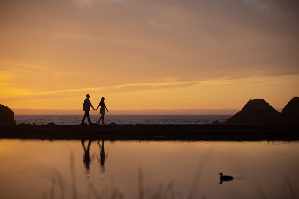 Sutro Baths sunset silhouette engagement picture of couple walking along the water