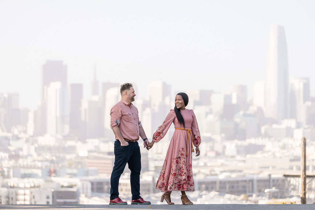 couple engagement photo in front of San Francisco skyline