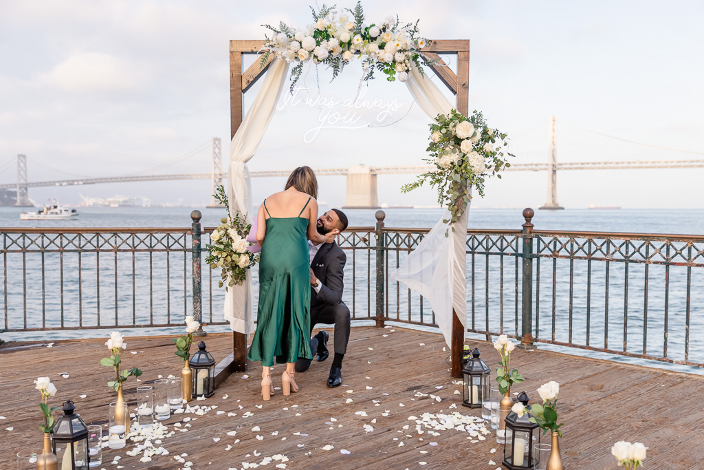 surprise proposal under the floral arch at pier 7