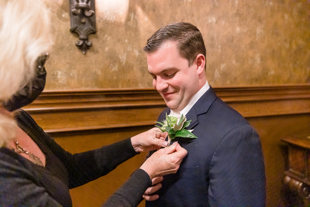 groom getting boutonniere pinned