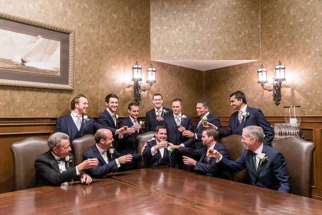 groom and groomsmen taking a shot of courage before wedding ceremony