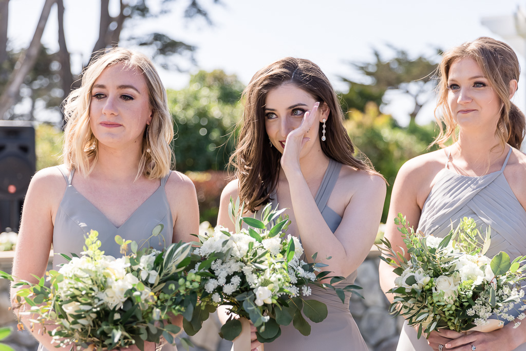 bridesmaids wiping off a tear during wedding ceremony