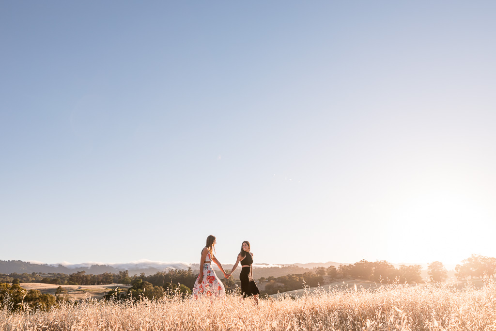 engagement photo of couple walking in rolling grassy hills