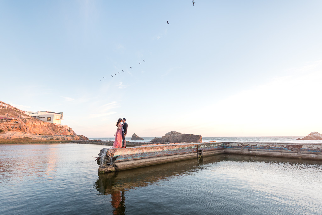 golden hour Sutro Baths engagement photo with birds in the sky