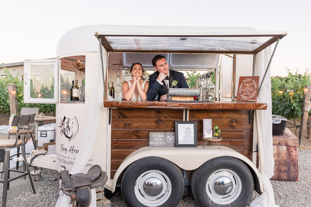 fun photo of the bride and groom inside the Tipsy Horse trailer