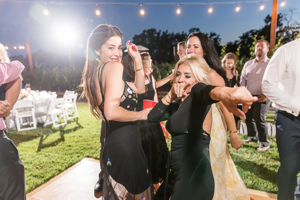 girls in black dancing during wedding reception