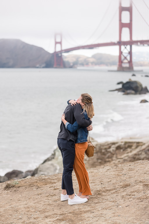 couple hugging in front of the Golden Gate Bridge
