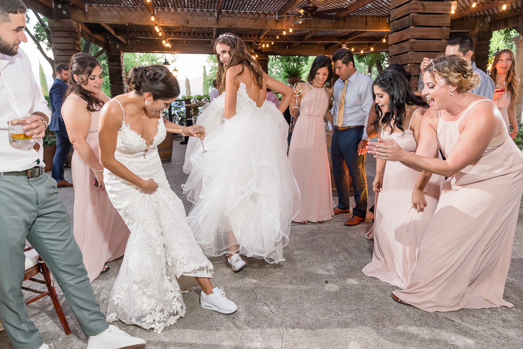 brides showing off their white flats for dancing