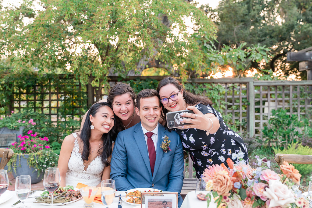 guests taking selfies with bride and groom