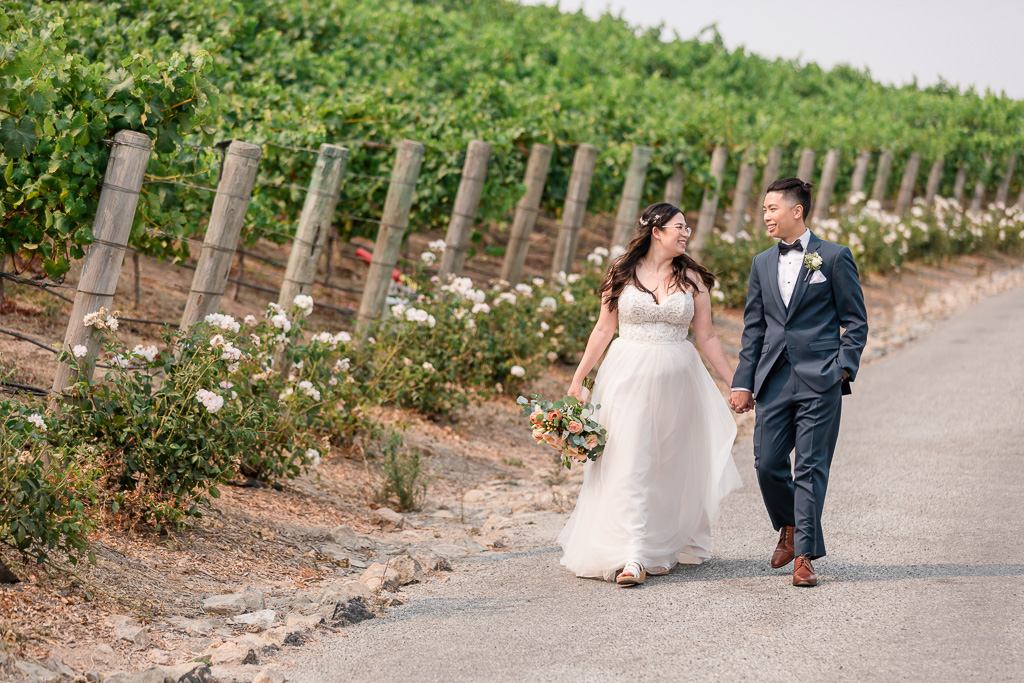 bride and groom by the vineyards at Nella Terra Cellars