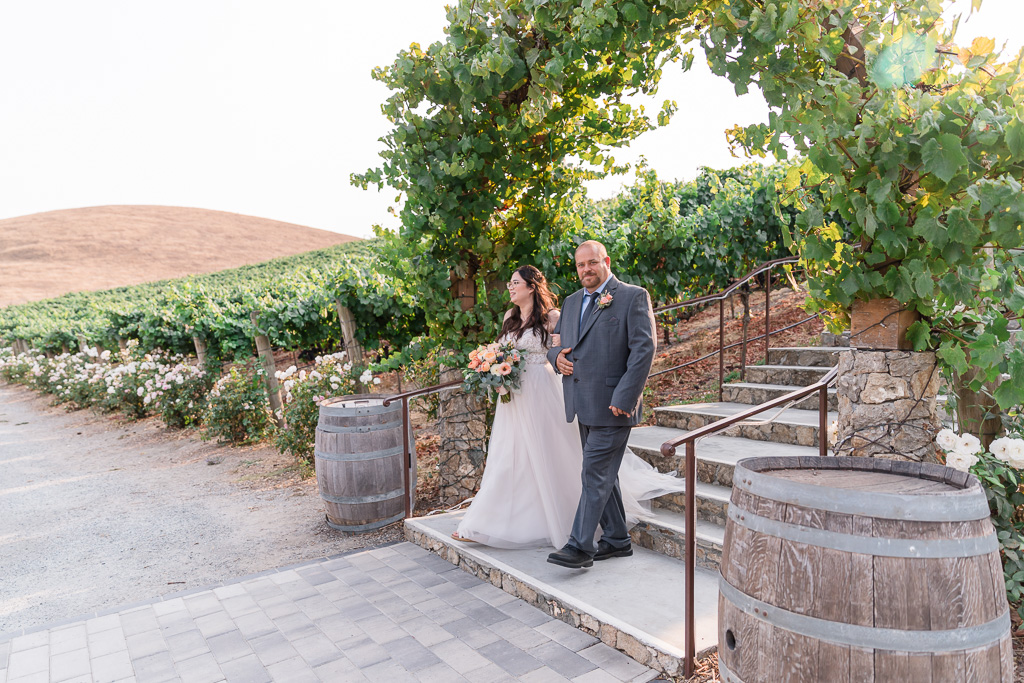 father and bride entering the wedding ceremony from the stairs at Nella Terra Cellars