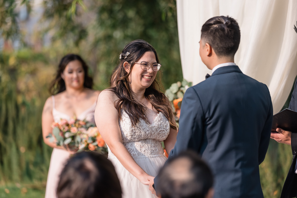 bride smiling at groom during wedding ceremony at Nella Terra Cellars