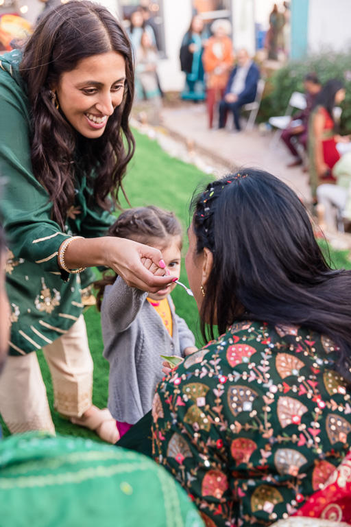 feeding the bride sweets during Indian mehndi ceremony