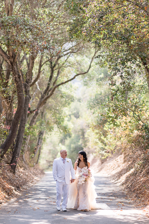newlyweds walking in the tree tunnel