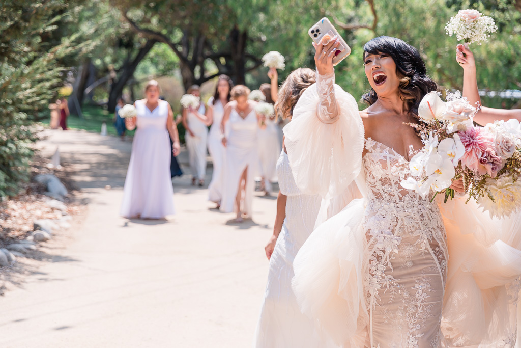 bride taking a selfie while walking with her gang