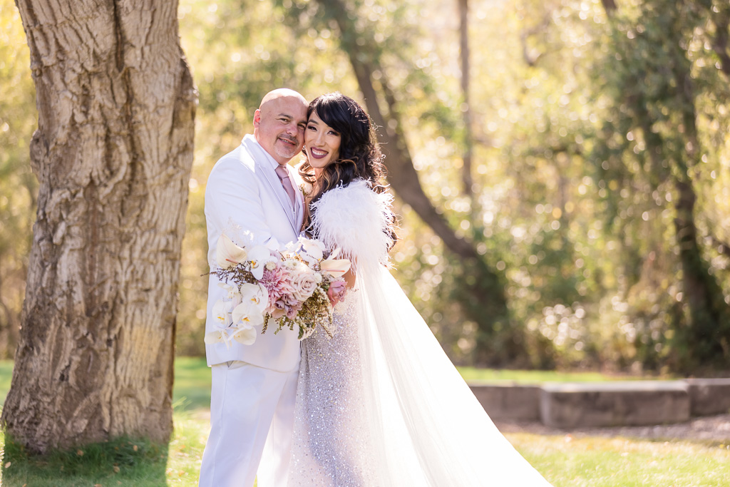 bride surprised groom with a sparkly reception gown and a feathery cape