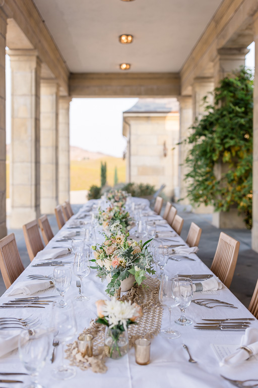 long wedding reception dinner table with elegant floral arrangement along center