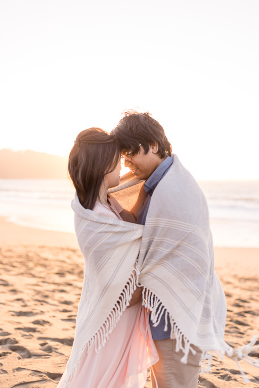 San Francisco soft romantic engagement photo on the beach with towel wrapped around