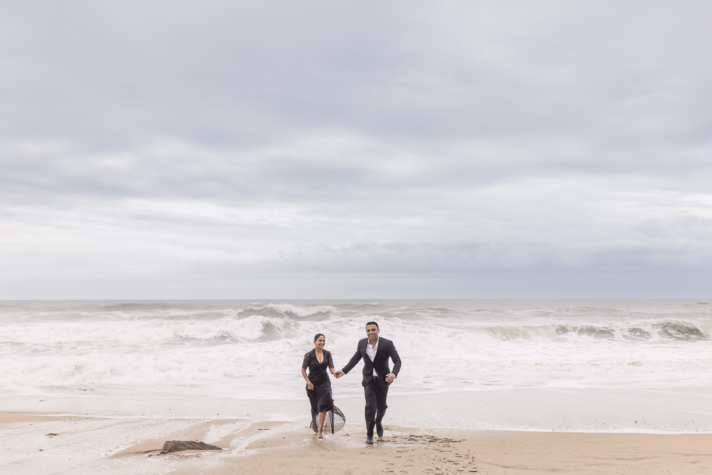 fun engagement photo running from the ocean waves