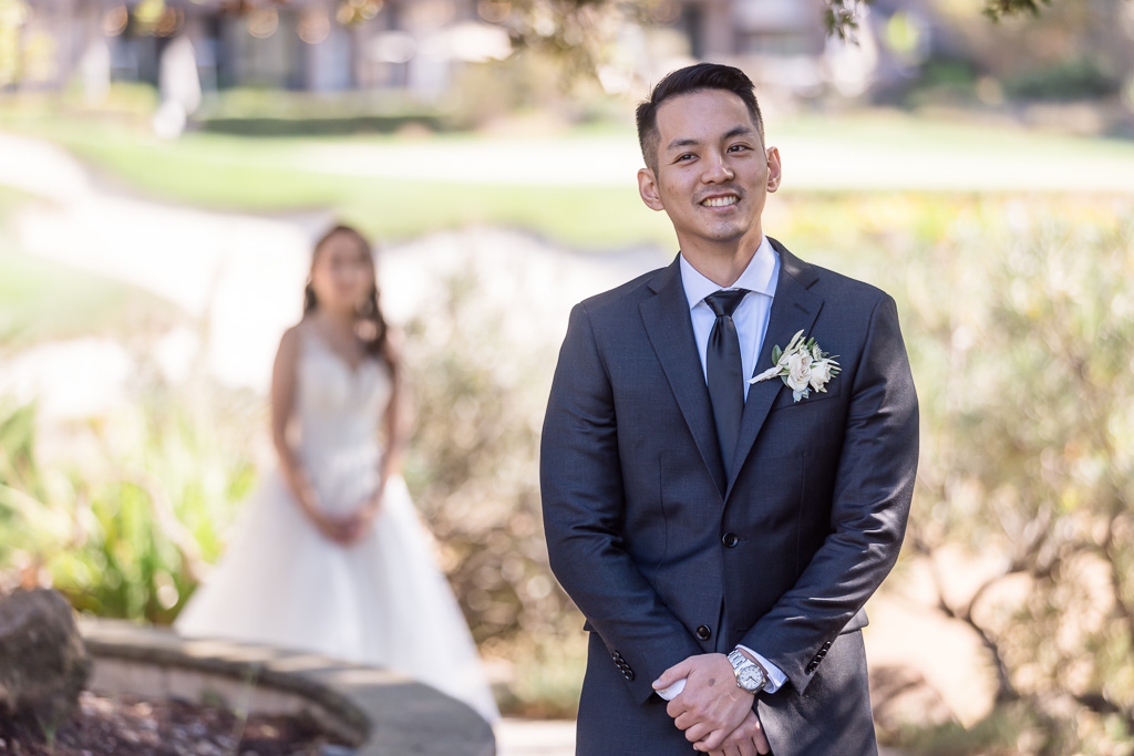 groom eager with anticipation as bride walks up to him for first look
