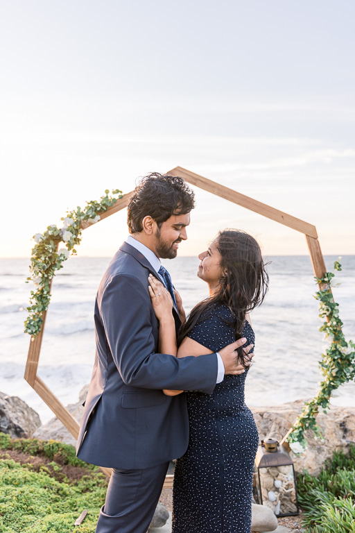 ocean sunset engagement photos with wooden arbor
