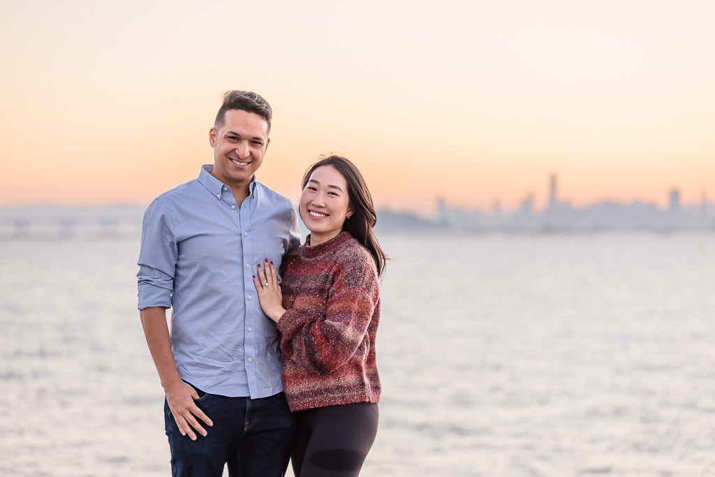 engagement photo in front of San Francisco sunset skyline