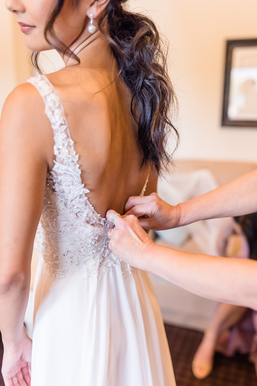 bride getting dress buttoned up