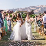 two brides cheerfully walking down the aisle after getting married