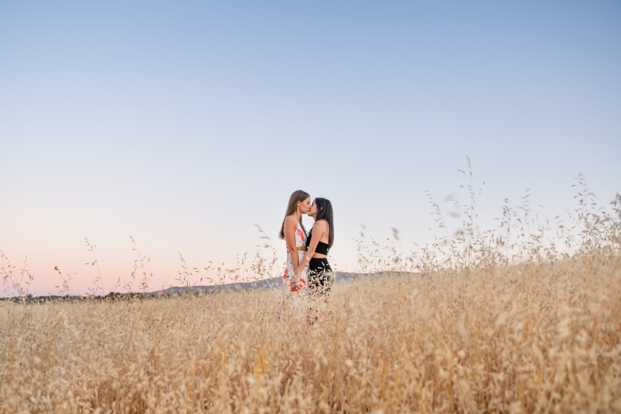 engagement photo of two women in an expansive grassy field