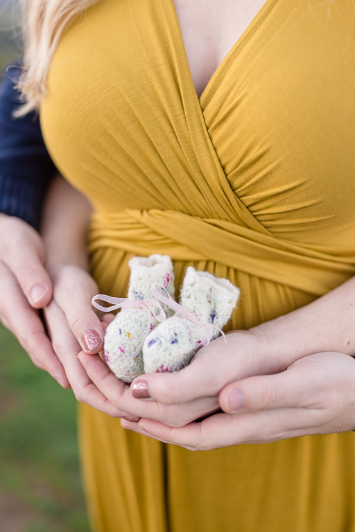 maternity photo with little baby shoes