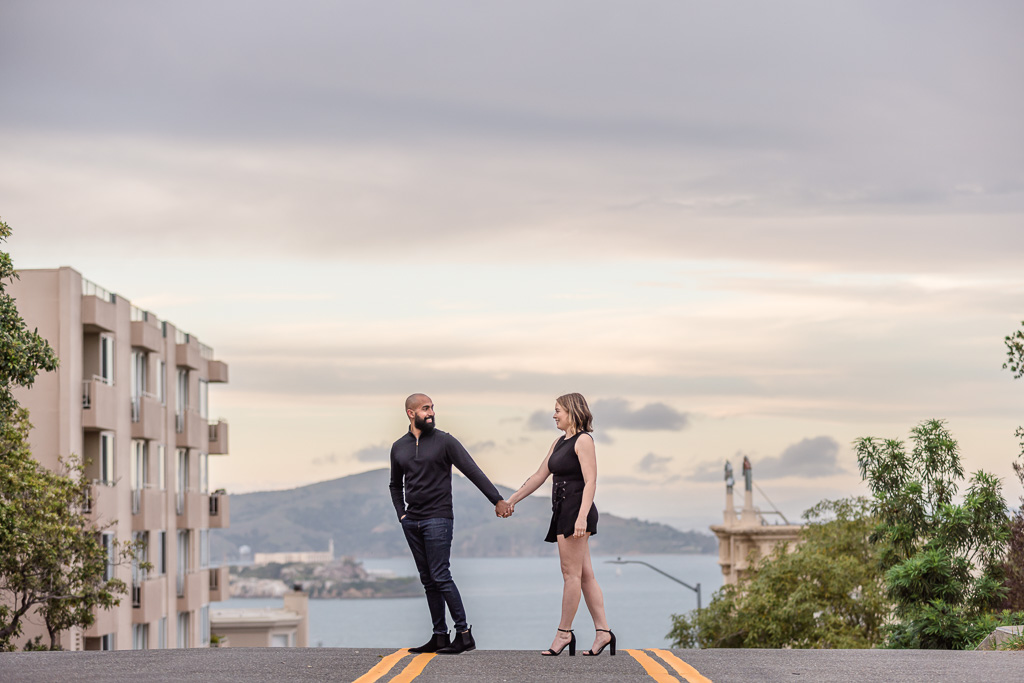 engagement photos crossing street in front of Alcatraz Island