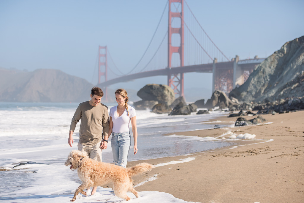 dog and couple playing in the ocean near the Golden Gate Bridge