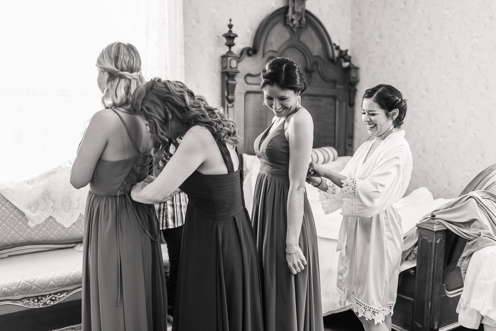 bride helping the bridesmaids for their dresses