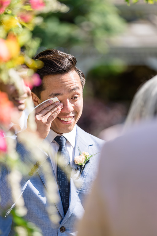 groom tearing up during garden wedding ceremony