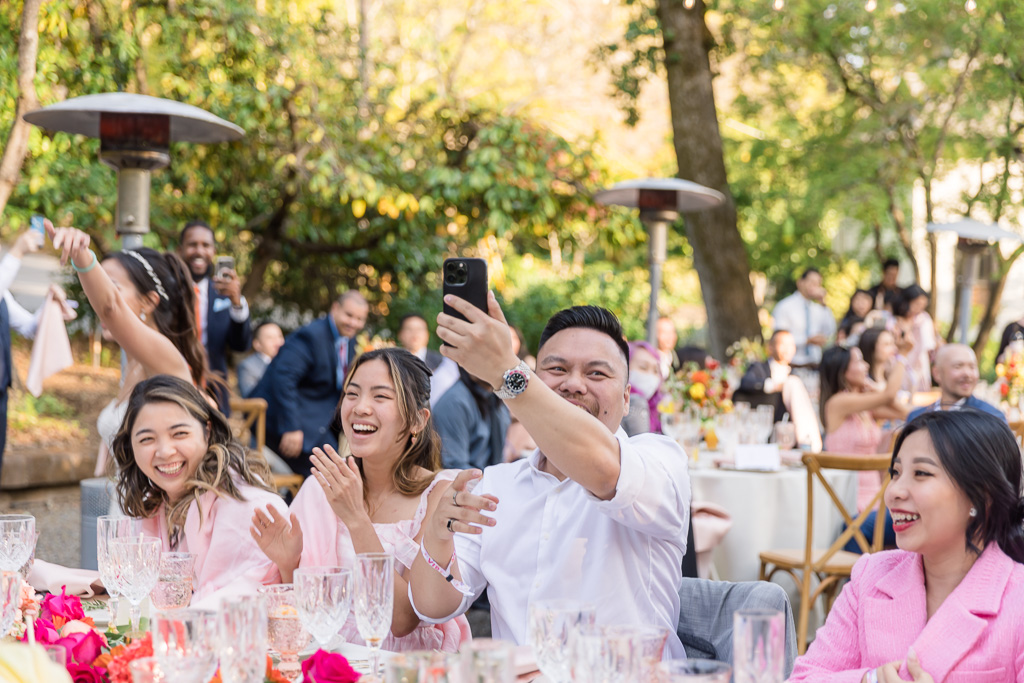 wedding guests having fun and snapping phone photos