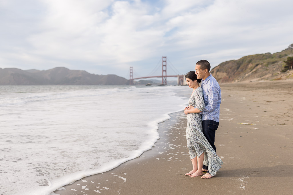 fun engagement photos on the beach with the Golden Gate Bridge