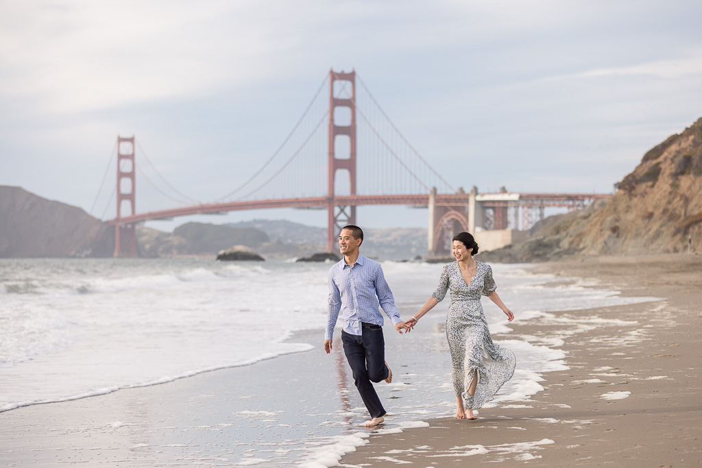 casual engagement pics at the beach by the Golden Gate Bridge