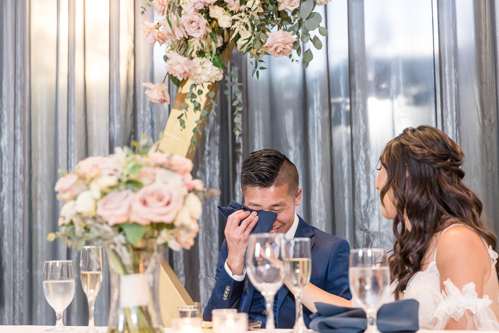 groom wiping away a tear during evening speeches