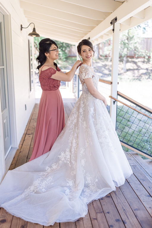 bridesmaid helping bride with dress