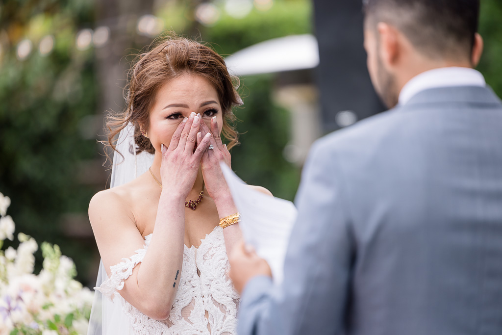 bride wiping a tear during wedding ceremony