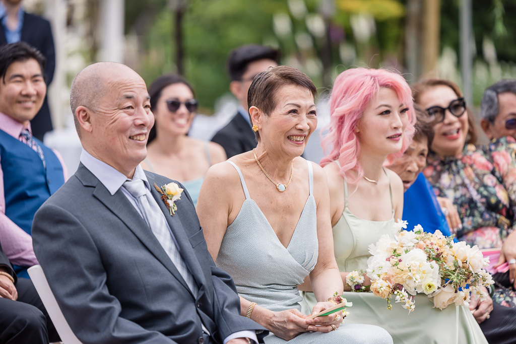 bride's mom and dad joyfully watching ceremony